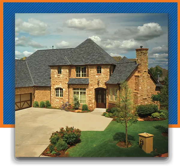 High-end, two-story brown brick home with a dark gray shingle roof